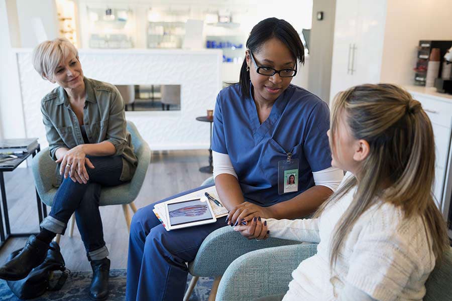 Nurse talking to teenager and mother